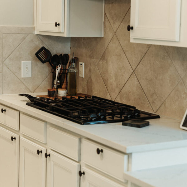 Modern kitchen upgrade featuring a sleek gas cooktop, quartz countertops, and custom cabinetry. Renovated with precision by expert general contractors serving Spring, Kingwood, and the Greater Houston Area.