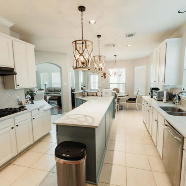 Spacious kitchen renovation with a sleek island, custom white cabinetry, and elegant pendant lighting. Designed for modern living by expert general contractors in Cypress, Kingwood, and surrounding Houston areas.