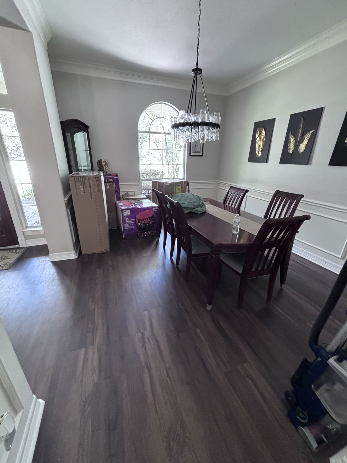 Stylish dining room featuring dark wood flooring, a modern chandelier, and elegant wainscoting. Expert home renovation and flooring installation available in Kingwood, Katy, and Cypress.