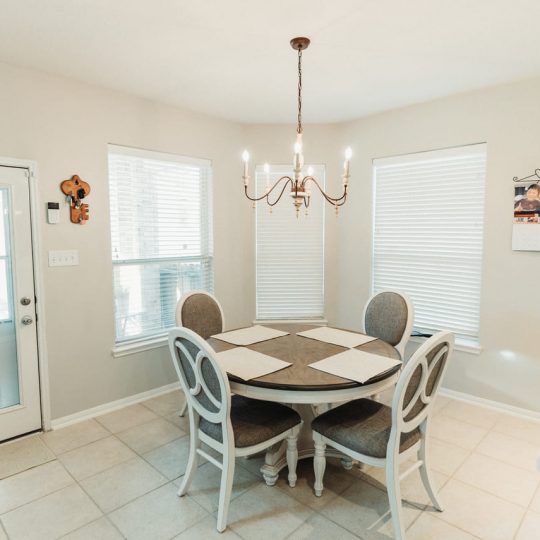 Cozy breakfast nook with a round dining table, elegant chandelier, and natural lighting. Thoughtfully designed as part of a full home renovation by expert contractors in Houston, Katy, and Pasadena.